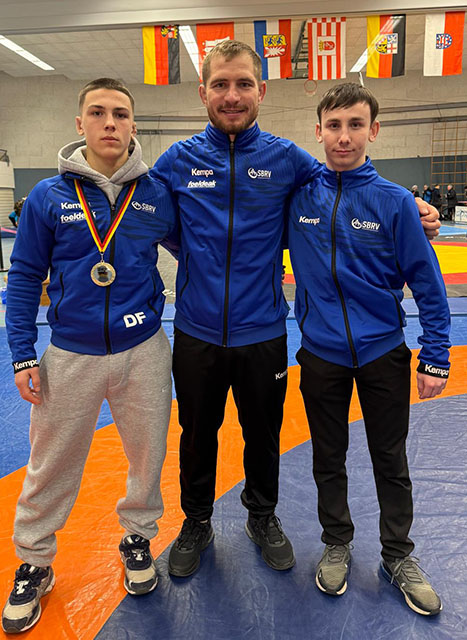 2025_01_18_Ringen_Bundesliga_RKG_Freiburg_2000_DRB_Sichtungsturnier_die_drei_RKG_Musketiere_Dario_der_Ringer_Ion_der_Trainer_Alessio_der_Kampfrichter_Sponsor_Hirsch_Bier_Wurmlingen